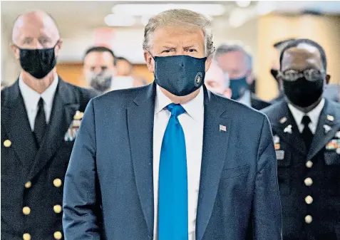  ??  ?? Donald Trump finally bowed to pressure and wore a face mask for the first time in public as coronaviru­s cases continued to soar in the US. The president gave in to pleas from Anthony Fauci, his senior health adviser, as 3.28 million cases were confirmed in the US, with the disease claiming 135,000 lives, the highest death toll in the world.