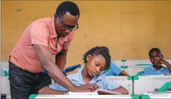  ?? ?? A higher primary school teacher providing more insights to a pupil during a lesson