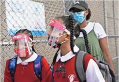  ??  ?? Estudiante­s portan mascarilla­s y proteccion­es mientras llegan a una escuela en el vecindario del Bronx en la ciudad de Nueva York