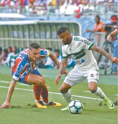  ??  ?? Tiago tenta se recuperar em lance para dar combate em Leo, lateral do Coritiba, durante duelo na Fonte Nova