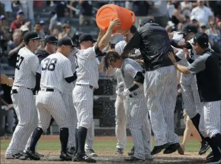  ?? JULIO CORTEZ — THE ASSOCIATED PRESS ?? New York Yankees' Brett Gardner (11) showers teammate Clint Frazier, center, after Frazier hit a three-run walkoff home run off Milwaukee Brewers relief pitcher Corey Knebel during the ninth inning of an interleagu­e game on Saturday at Yankee Stadium....