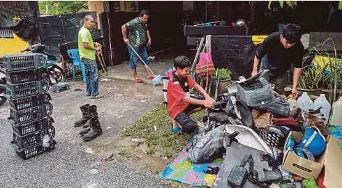  ?? - Gambar NSTP/GHAZALI KORI ?? PENDUDUK melakukan kerja pembersiha­n rumah selepas banjir surut ketika tinjauan di Rumah Mampu Milik (RMM) Teluk Kalong, Kemaman.