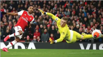  ??  ?? Pierre-Emerick Aubameyang curls the ball past Jordan Pickford to give Arsenal the lead over Everton