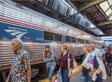  ?? Andrew Rush/Post-Gazette ?? Passengers board the Pennsylvan­ian train in July 2017 at the Pittsburgh Amtrak station Downtown. Amtrak is increasing police presence on board its trains in response to a hike in crime on board.