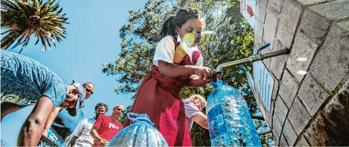  ?? Foto: Morgana Wingard, Getty Images ?? Schon jetzt ist das Leitungswa­sser in Kapstadt streng rationiert. Deshalb füllen viele Einwohner, so auch dieses Mädchen, ihre Vorräte an öffentlich­en Quellen wie dieser im Stadtteil Newlands auf.