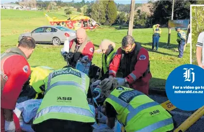  ?? Photos / Doug Sherring, Supplied ?? Above: George Scott is flanked by Sam Allen (left) and Aran Fairley, the first of many to work on him. Left: All hands on deck as responders battle to pull Scott back from the brink.