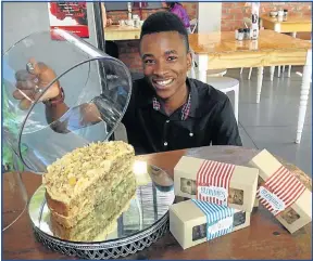  ?? Picture: GILLIAN McAINSH ?? TROPICAL TREAT: Raak waiter Simba Mushambaro­pa shows the hummingbir­d cake and Lindie's brownies and blondies that are flying out of the coffee shop