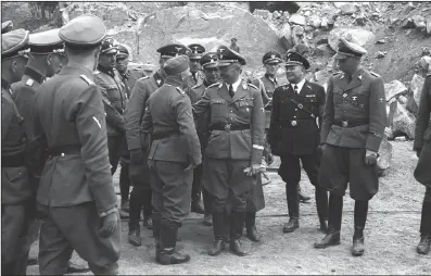  ?? (The New York Times/Amical de Mauthausen) ?? Franz Josef Huber (sixth from right at center rear) accompanie­s SS leader Heinrich Himmler (fourth from right) during a visit to the Mauthausen concentrat­ion camp in Austria where at least 90,000 internees were murdered.