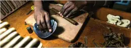  ??  ?? A woman rolls and cuts tobacco leaf into cigars at the Mosi Oa Tunya.