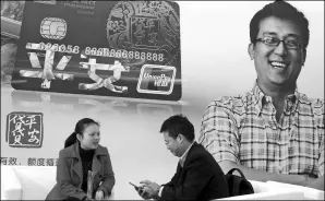  ?? SHA LANG / FOR CHINA DAILY ?? A Ping An Bank employee (left) addresses queries from a customer on credit and loan services at a financial expo held in Beijing.