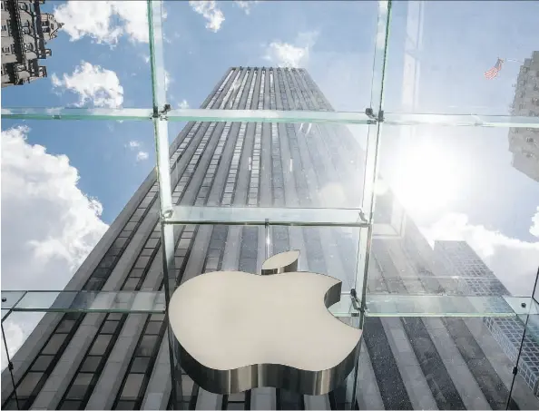  ?? ANDREW BURTON/GETTY IMAGES/FILE ?? The Apple logo hangs on the Apple Store on Fifth Avenue in New York City. For the fourth quarter, the company posted net income of US$11.1 billion, or US$1.96 a share, while sales rose 22 per cent to US$51.5 billion.