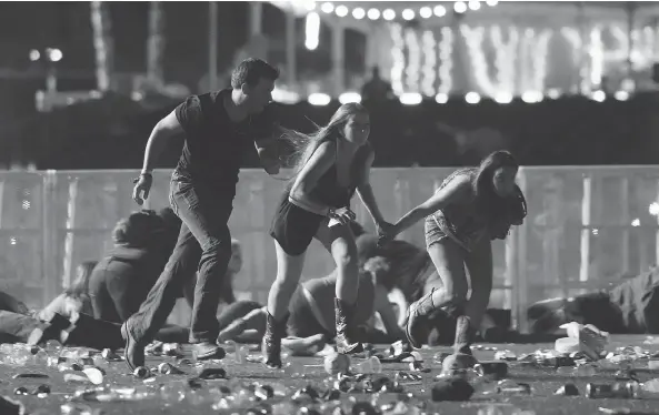  ?? DAVID BECKER / GETTY IMAGES ?? People run from gunfire at the Route 91 Harvest country music festival in Las Vegas late Sunday after a gunman opened fire on concertgoe­rs from a nearby hotel.