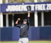  ?? David J. Phillip/Associated Press ?? The New York Yankees’ Giancarlo Stanton reaches to catch a ball during a spring training workout on Monday in Tampa, Fla.