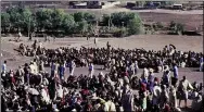  ??  ?? Drought victims sit on the ground at the refugee camp in Bati, on the southweste­rn edge of Ethiopia’s Danakil Desert area in November 1984.