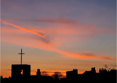  ??  ?? A beautiful sunset and the cross of a church in Bath. By Mike Thornberry.