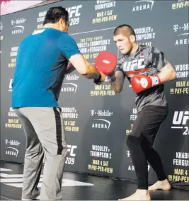  ?? HEIDI FANG/ LAS VEGAS REVIEW-JOURNAL @HEIDIFANG ?? UFC lightweigh­t contender Khabib Nurmagomed­ov from Russia spars with coach Javier Mendez during a UFC 209 open workout Wednesday at T-Mobile Arena. Nurmagomed­ov was hospitaliz­ed overnight Thursday while trying to make weight for his now-canceled...