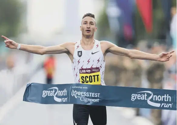  ??  ?? Marc Scott celebrates at the finish line of the Great North Run.