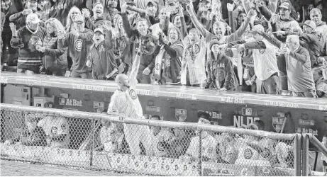  ?? Charles Red Arbogast photos / Associated Press ?? Cubs reliever Travis Wood receives a curtain call from the crowd at Wrigley Field after hitting a solo home run in the fourth inning Saturday night, becoming the first reliever to hit a postseason homer since 1924.