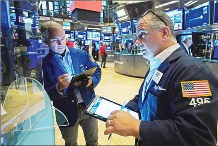  ?? (AP) ?? In this file photo, traders Timothy Nick, left, and Joel Luchese work on the floor of the New York Stock Exchange. Stocks fell Wednesday as investors remain on the sidelines until they get more guidance from the Federal Reserve as well as the direction of the coronaviru­s pandemic.