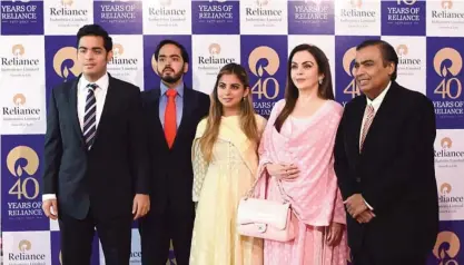  ??  ?? MUMBAI: India’s richest man and oil-to-telecom conglomera­te Reliance Industries chairman Mukesh Ambani, right, and his wife Nita Ambani (2R) pose with their children (L-C) Akash Ambani, Anant Ambani and Isha Ambani as they arrive for the company’s 40th...