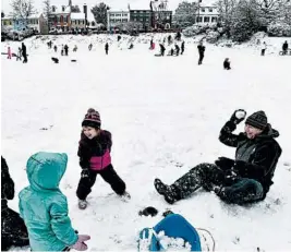  ?? MATT MCCLAIN/WASHINGTON POST ?? Tom Weiler, left, and daughter, Clare Rose Weiler, 3, have a snowball fight Sunday with Cecily Britt, 3, center, and her father, Ben Britt, during a snowstorm in Alexandria, Va.
