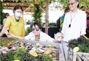  ?? PHOTO BY ALEX BADAYOS ?? SEAFOOD ABOUNDS. Cebu Gov. Gwendolyn Garcia proudly presents the seafood caught in Bantayan town during the town’s food fair held on Thursday, April 15, 2021. With her is Bantayan Mayor Arthur Despi and culinary writer Louella Eslao-Alix.