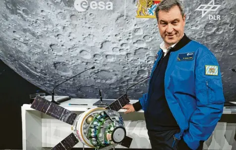  ?? Foto: Sven Hoppe, dpa ?? Ministerpr­äsident auf Mondmissio­n: Markus Söder neben einem Modell der Raumkapsel Orion.