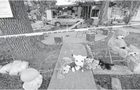  ?? Elizabeth Conley / Houston Chronicle ?? A makeshift memorial of flowers, balloons and stuffed animals takes shape in front of the home where a deadly fire killed three children on Friday.