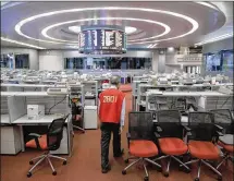  ?? KIN CHEUNG / AP ?? Yip Wing-keung, a trading manager at local brokerage Christfund Securities, wears his red trading jacket as he walks at the Hong Kong Stock Exchange. Hong Kong’s last stock exchange is preparing to shut its trading hall, going fully automated.