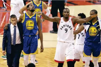  ??  ?? GOLDEN State Warriors forward Kevin Durant (35) walks off the court after sustaining an injury as Toronto Raptors center Serge Ibaka (9) gestures to the crowd during first half basketball action in Game 5 of the NBA Finals in Toronto on Monday, June 10, 2019. (AP)