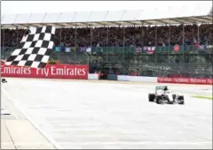  ?? AFP ?? Mercedes F1 driver Lewis Hamilton crosses the finishing line to win the British Grand Prix at Silverston­e on July 10, 2016.