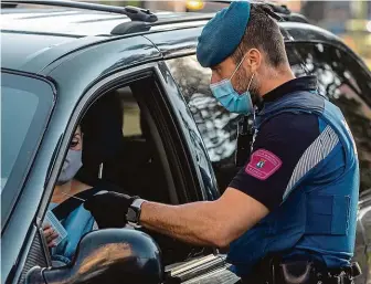  ?? FOTO ČTK/AP ?? Uzavřená oblast se stala z části Madridu. Na snímku policista kontroluje na checkpoint­u řidičku.