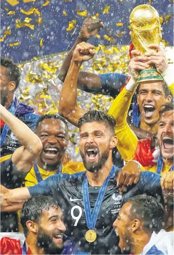  ??  ?? con el trofeo más preciado entre sus manos. Lo rodean Giroud, Mbappé, Varane, Gr riezmann y Fekir, entre otros. Alegría en medio de una intensa lluvia.