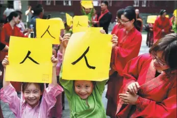  ?? FU XINCHUN / FOR CHINA DAILY ?? Children show off their calligraph­y — the Chinese word (human) — in Cangzhou, Hebei province, on Wednesday. The community held a traditiona­l Pen-Opening Ritual as the first lesson for 25 children who are about to start school.