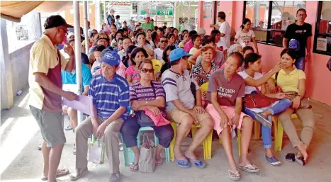  ??  ?? LINGAP LINE. Around 100 seeking medical help at Lingap Para sa Bayan office in front of Southern Philippine­s Medical Center in Davao City endure the afternoon heat while others skip lunch just to keep in line. MACKY LIM