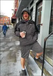  ?? PAUL POST — PPOST@DIGITALFIR­STMEDIA.COM ?? Saratoga Springs City Tavern employee Josh Stone ran errands on Friday wearing shorts before heading back inside to his warm kitchen workplace.