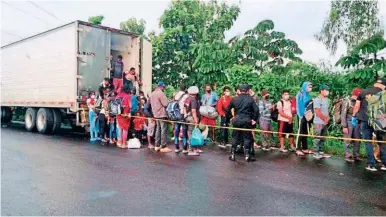  ?? FOTO EFE ?? Fuerzas de seguridad guatemalte­ca atienden a los 129 migrantes rescatados del furgón.