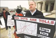  ?? Brian A. Pounds / Hearst Connecticu­t Media ?? Patrick Sasser, of Stamford, and protesters from the group No Tolls CT, hold signs outside the Capitol in Hartford on Wednesday. Gov. Ned Lamont has proposed tolls on state highways to pay for transporta­tion improvemen­ts.