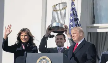  ?? EVAN VUCCI/ASSOCIATED PRESS ?? Washington Nationals infielder Ryan Zimmerman, who starred at Kellam High and the University of Virginia, hoists the Commission­er's Trophy on Monday while flanked by First Lady Melania Trump and President Donald Trump.