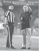  ?? ROB SCHUMACHER/AZCENTRAL SPORTS ?? Arizona State coach Todd Graham watches a replay of the Sun Devils’ first touchdown on the new video board against New Mexico State in the first quarter at Sun Devil Stadium on Thursday night in Tempe.