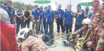 ??  ?? Mut (third right) listens attentivel­y when briefed by Fire and Rescue personnel on safety and rescue equipment.