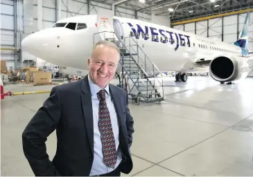  ?? PHOTOS: WIL ANDRUSCHAK, POSTMEDIA CONTENT WORKS ?? Ed Sims, president and chief executive officer of WestJet, with one of the airline’s new Boeing 737s.
