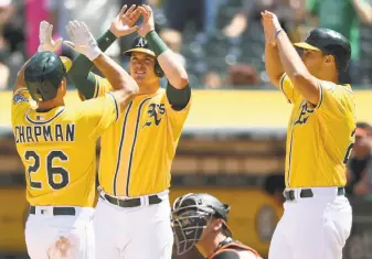  ?? Photos by Thearon W. Henderson / Getty Images ?? Oakland’s Matt Chapman, Ryon Healy (center) and Matt Olson celebrate after Chapman hit a three-run homer against Baltimore.