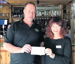  ??  ?? ■ Pied Bull manager Andy Doug hands over a cheque to Steps manager Janet Russell.