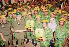  ?? PIC BY NIK ABDULLAH NIK OMAR ?? Umno informatio­n chief Tan Sri Annuar Musa handing out uniforms to People’s Volunteer Corps members at SMK Kadok, Kota Baru, yesterday.