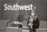  ?? Smiley N. Pool/Dallas Morning News/TNS ?? A Southwest Airlines agent works at a checkin counter at Love Field in Dallas.