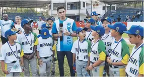  ??  ?? ADMIRADO. El beisbolist­a hondureño Mauricio Dubón estuvo asediado por los niños. Aquí habla con los medios junto a los brasileños.