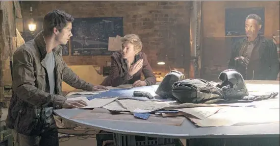  ?? Joe Alblas ?? THOMAS (Dylan O'Brien), left, and Newt (Thomas Brodie-Sangster) debate what action to take as Jorge (Giancarlo Esposito) watches in the latest “Maze Runner.”