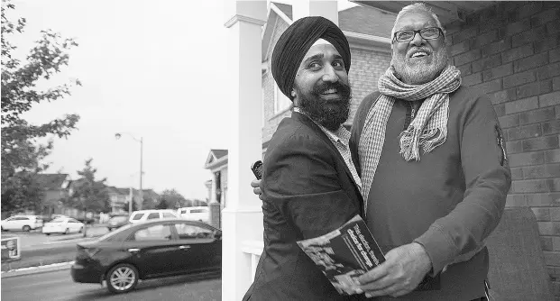  ?? Laura Pedersen / National
Post ?? Harbaljit Singh Kahlon, left, NDP candidate for Brampton East, gets a hug from a man identified as Swaran as he campaigns in Brampton, Ont.