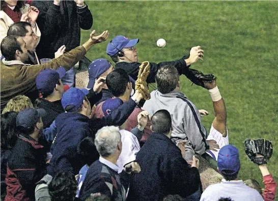  ?? Picture / AP ?? The moment in 2003 when Steve Bartman ( in blue cap and headphones) earned the ire of Chicago Cubs fans — interferin­g with a catch during a game which could have seen the Cubs qualify for the World Series they haven’t won since 1908.